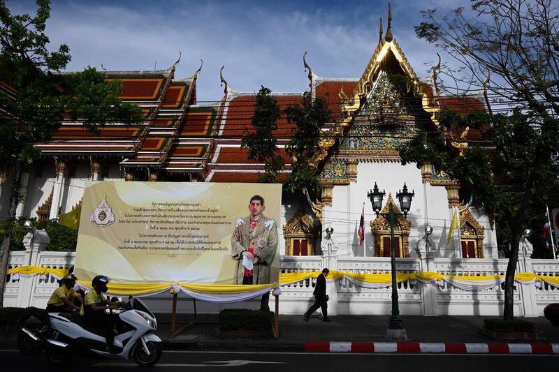 People make their way in front of a portrait of Thailand's King, ahead of the coronation.  AFP
