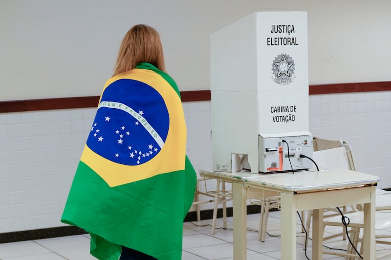 A voter wrapped in a Brazilian flag arrives to vote in the presidential run-off. AP