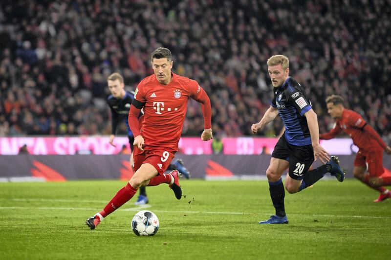 MUNICH, GERMANY - FEBRUARY 21: Robert Lewandowski of Bayern Muenchen runs with the ball next to Laurent Jans of Paderborn during the Bundesliga match between FC Bayern Muenchen and SC Paderborn 07 at Allianz Arena on February 21, 2020 in Munich, Germany. (Photo by Sebastian Widmann/Bongarts/Getty Images)