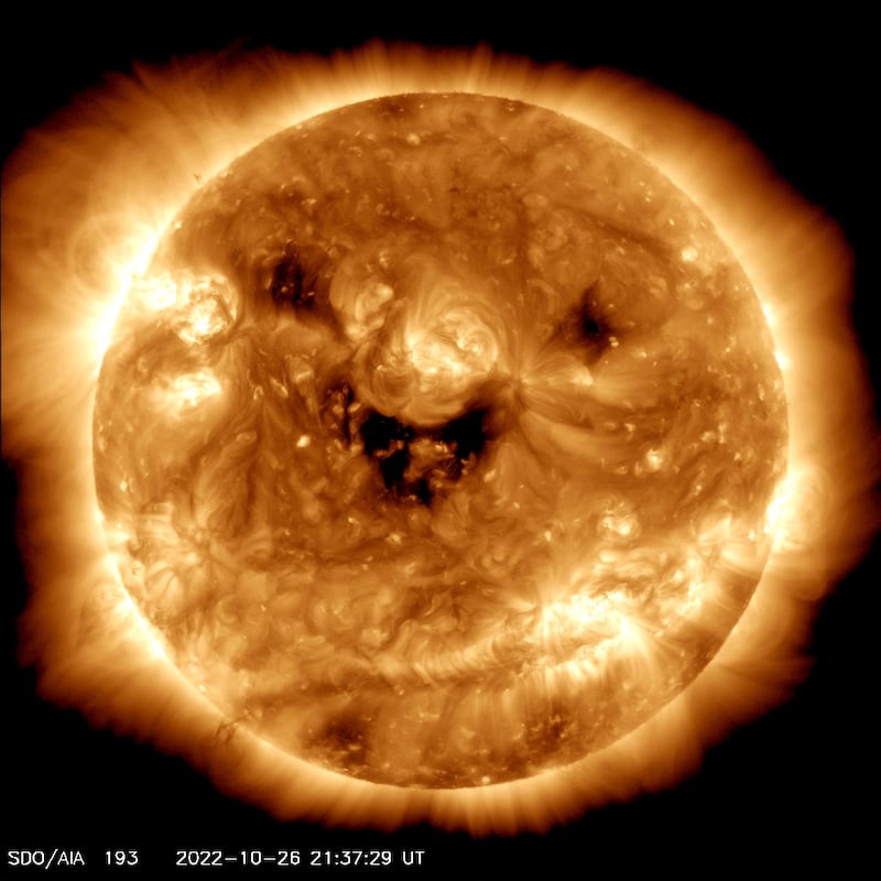 Satellite imagery shows the Sun in ultraviolet light colourised in light brown. Dark patches on its surface are in the shape of a smile. Photo: Nasa