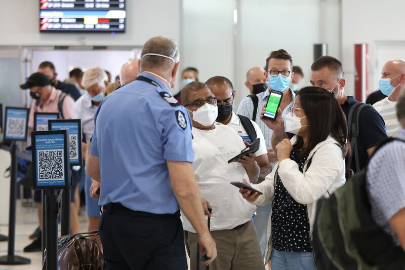 Arriving passengers and Western Australia police officer at Perth Airport.