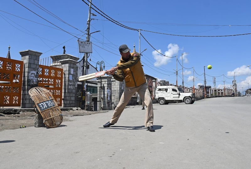 An Indian police officer plays cricket on a deserted road, during a strike called by Kashmiri separatists, in downtown Srinagar. Danish Ismail / Reuters