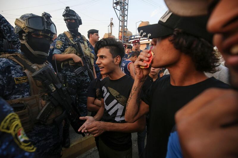 Iraqi protesters speaks with members of police in Baghdad's predominantly Shiite Sadr City. Demonstrations across Baghdad and the south have spiralled into violence over the last week, with witnesses reporting security forces using water cannons, tear gas and live rounds and authorities saying "unidentified snipers" have shot at protesters and police. On Sunday evening a mass protest in Sadr City in east Baghdad led to clashes that medics and security forces said left 13 people dead. AFP