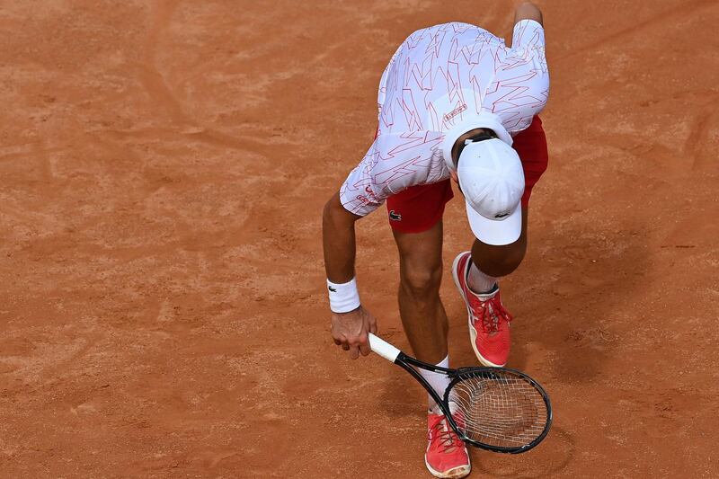 Serbia's Novak Djokovic checks his broken racket during is match with Germany's Dominik Koepfer during their quarterfinals at the Italian Open tennis tournament, in Rome, Saturday, Sept. 19, 2020. (Alfredo Falcone/LaPresse via AP)
