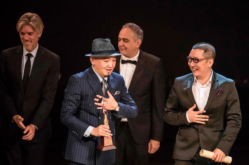 Chinese directors Zhang Chong and Zhang Bo receive the Bronze Pyramid for 'The Fourth Wall' during the closing ceremony of the 41st Cairo International Film Festival. AFP