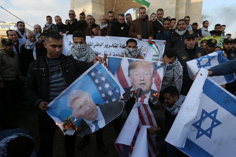 Palestinian demonstrators burn pictures depicting US President Donald Trump and Israeli Prime Minister Benjamin Netanyahu, and repsentations of US and Israeli flags during a protest in the southern Gaza Strip January 29, 2020. Reuters