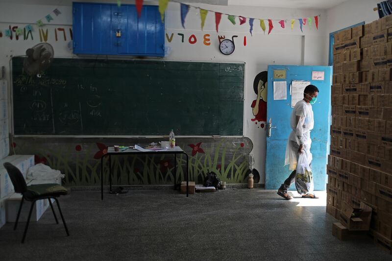 A UN worker delivers aid to Palestinian families at a school in Gaza City. Reuters