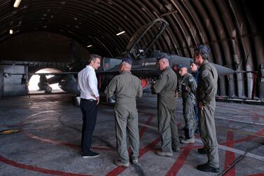 Greece's Prime Minister Kyriakos Mitsotakis speaks with officers during his visit to the air force base in Crete. AP
