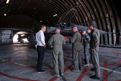 In this photo provided by the Greek Prime Minister's Office, Greece's Prime Minister Kyriakos Mitsotakis, left, speaks with officers during his visit at the Air Force base in Souda, on the southern island of Crete, Greece, Saturday, Aug. 15, 2020. The European Union's foreign policy chief expressed "full solidarity" with Greece and Cyprus and urged a "immediate deescalation" by Turkey after EU foreign ministers held urgent talks Friday on high military tensions over offshore drilling rights in the eastern Mediterranean. (Dimitris Papamitsos/Greek Prime Minister's Office via AP)