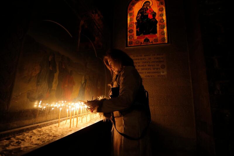 Syrian Orthodox Church believers light candles during a Christmas service in Damascus. EPA