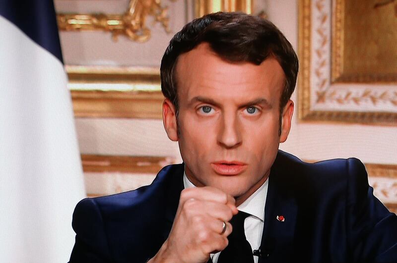 French President Emmanuel Macron is seen on a television screen as he speaks during an address to the nation in Paris. AFP