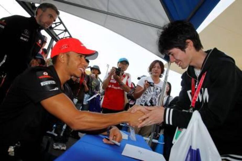 McLaren driver Lewis Hamilton of Britain  shakes hands with a spectator during the autograph session on the Suzuka Circuit at the Japan Formula One Grand Prix in Suzuka, Thursday, Oct. 6, 2011. (AP Photo//Eugene Hoshiko) *** Local Caption ***  Japan F1 GP Auto Racing.JPEG-0146a.jpg