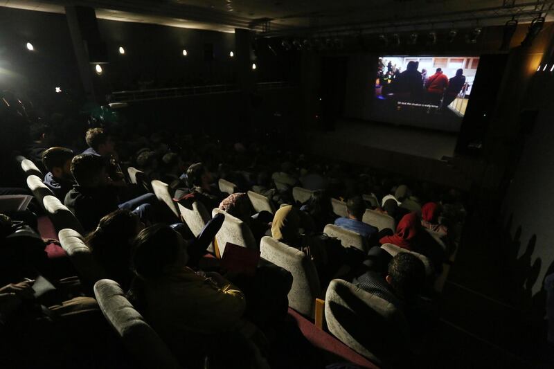 GAZA CITY, GAZA - NOVEMBER 26: People watch a movie, directed by Palestinian journalist Yaser Murtaja, who was killed by Israeli soldiers, during the 4th edition of the Red Carpet Film Festival in Gaza City, Gaza on November 26, 2018. (Photo by Ashraf Amra/Anadolu Agency/Getty Images)