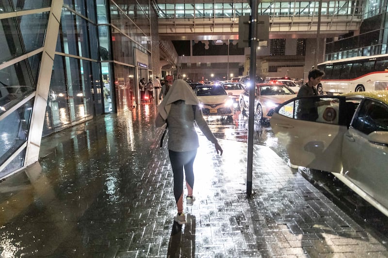A pedestrian walks through the rain in Dubai. Antonie Robertson / The National


