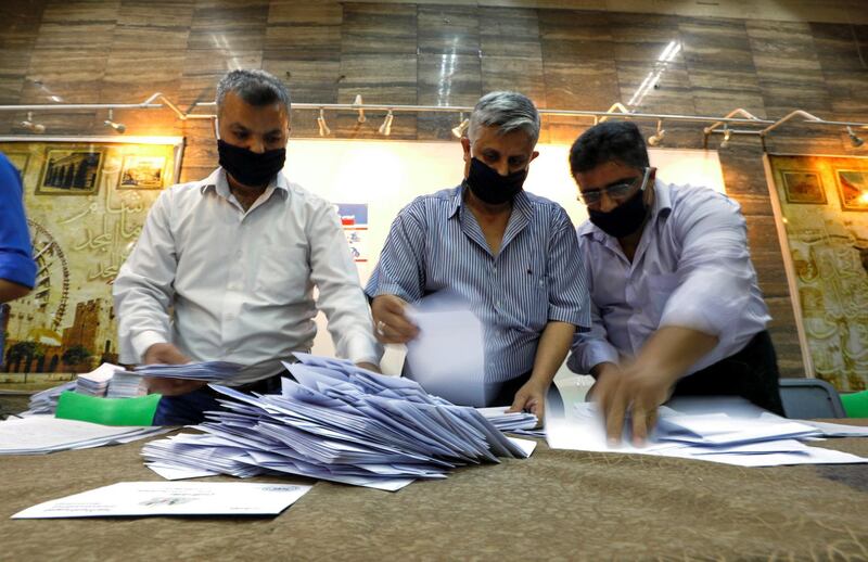 Men count ballots at a polling station during parliamentary election in Damascus. Reuters