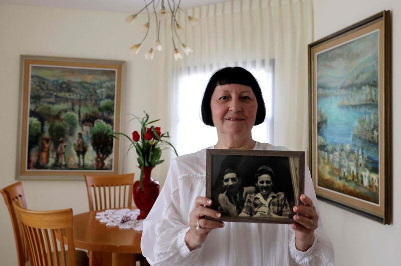 Shoshana Greenberg, 74, the daughter of a Holocaust survivor, holds a picture of her parents Regina and Israel, at her home in Tel Aviv.