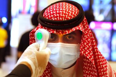 A Saudi cinema viewer has his temperature taken as he wears a face mask to help curb the spread of the coronavirus, at VOX Cinema hall in Jeddah, Saudi Arabia, Friday, June 26, 2020. AP