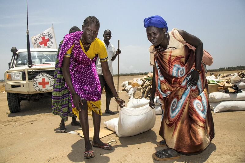 Women carry a sack of seeds distributed by the International Committee of the Red Cross (ICRC) in the opposition controlled town of Thonyor, in Leer county, on April 11, 2017. - The United Nations warned on APril 11 of a growing risk of mass deaths from starvation among people living in conflict and drought-hit areas of the Horn of Africa, Yemen and Nigeria. An "avoidable humanitarian crisis... is fast becoming an inevitability", as the UN faces a "severe" funding shortfall to help people affected by famine, said UN refugee agency spokesman Adrian Edwards. UNHCR's operations in famine-hit South Sudan, and in Nigeria, Somalia and Yemen, which are on the brink of famine, are funded at between just three and 11 percent, he told reporters in Geneva. (Photo by Albert Gonzalez Farran / AFP)