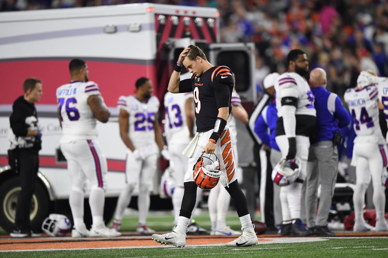 Cincinnati Bengals quarterback Joe Burrow walks across the field as Damar Hamlin is examined by medical staff. AP