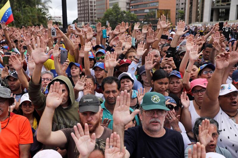 epaselect epa07313236 Citizens raise their hands as Juan Guaido, President of the Venezuelan Parliament, announces that he assumes executive powers, in Caracas, Venezuela, 23 January 2019. Guaido declared himself interim president of Venezuela - a move that was quickly recognised by US President Trump -  in fight against President Maduro whose presidency Guaido considers 'illegitimate'. The USA and South American countries have been pressing for Maduro's ouster more strongly in the past weeks, aimed to end his presidency after years of crisis.  EPA/Miguel GutiÃ©rrez