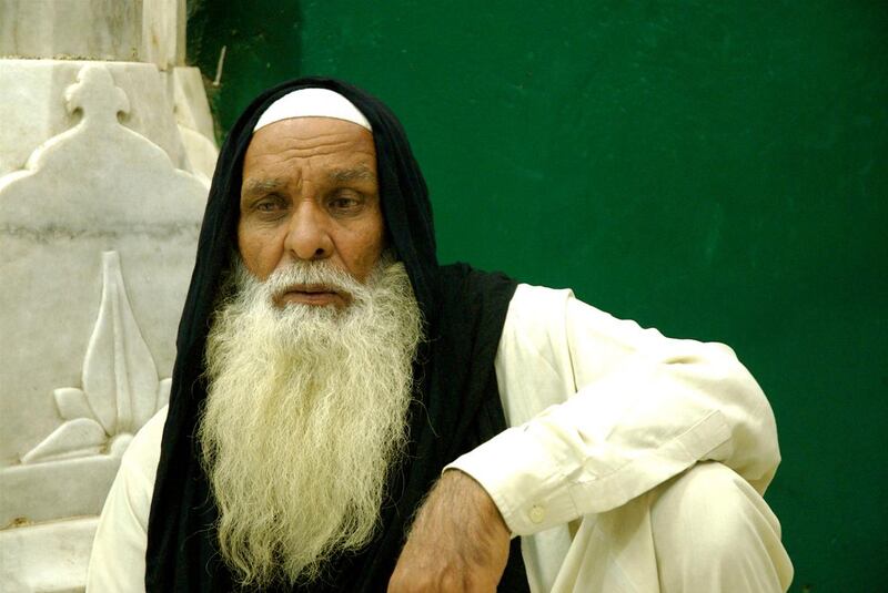 A malang, colourfully dressed ascetics who reflect the non-conformity of the Sufi philosophy, sits at the Data Darbar shrine , Lahore, Pakistan, By Matthew Tabaccos for The National