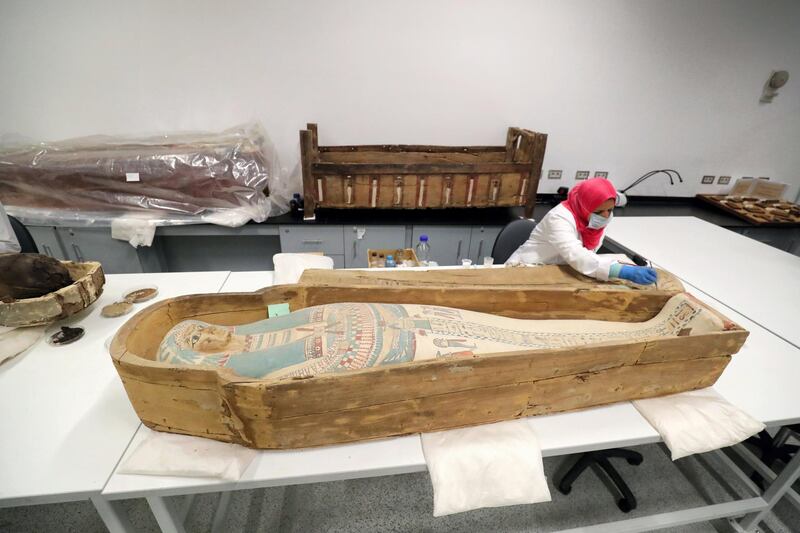 An Egyptian archaeologist restores the coffin of King Tutankhamun at the conservation center in the Grand Egyptian Museum on August 4, 2019. - For the first time since the tomb was discovered in 1922, the coffin was transported from King Tutankhamun's tomb at the Valley of the Kings in Luxor to the Grand Egyptian Museum for an eight-month restoration process, before being displayed among his treasured collection at the museum. Tutankhamun is the formal name of the mummified pharaoh most tourists visiting Egypt's Valley of the Kings know as King Tut. (Photo by Khaled DESOUKI / AFP)