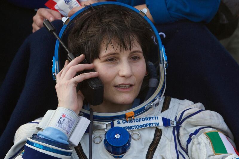 FILE - In this June 11, 2015 file photo, Italian astronaut Samantha Cristoforetti speaks by satellite phone outside of the Soyuz TMA-15M space capsule after she and U.S. astronaut Terry Virts and Russian cosmonaut Anton Shkaplerov landed in a remote area outside the town of Dzhezkazgan, Kazakhstan. The ESA, NASA's European equivalent, is highlighting diversity in the drive: The final frontier for such predominantly white and male agencies. This year the ESA is looking to recruit more women astronauts, as well as people with disabilities who always dreamed of going into space.(AP Photo/Ivan Sekretarev, Pool, File)