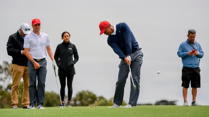 Captain of the US team Tiger Woods (C) hits to the green during a practice round. AFP