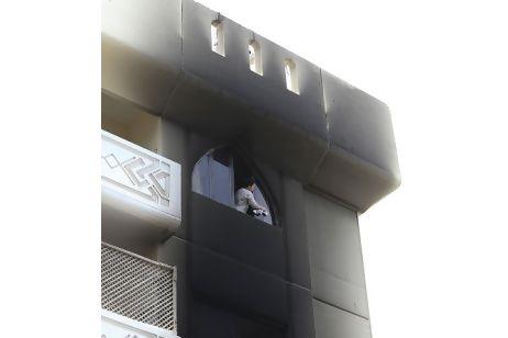 A maid cleans a blackened window on the 18th floor a day after a fire tore through Al Sadaf tower on Electra street, Abu Dhabi. Sarah Dea/The National