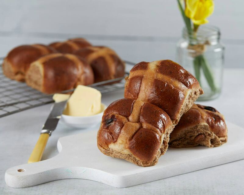 hot cross buns on chopping board with butter