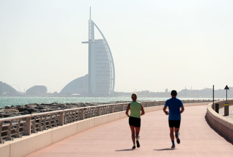 People enjoy a run on the Palm Jumeirah on a hazy but bright day in Dubai. Photo: Chris Whiteoak / The National