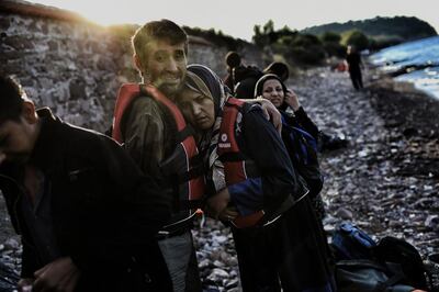 A man hugs his wife upon their arrival to the Greek island of Lesbos after crossing the Aegean sea from Turkey. AFP