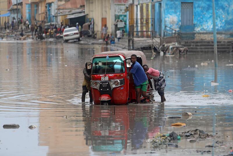 Somali men push their rickshaw through flood waters after rainfall in Mogadishu.  Reuters