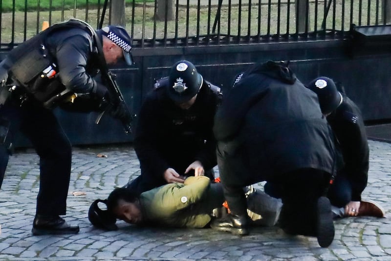 A man is detained by police. AFP