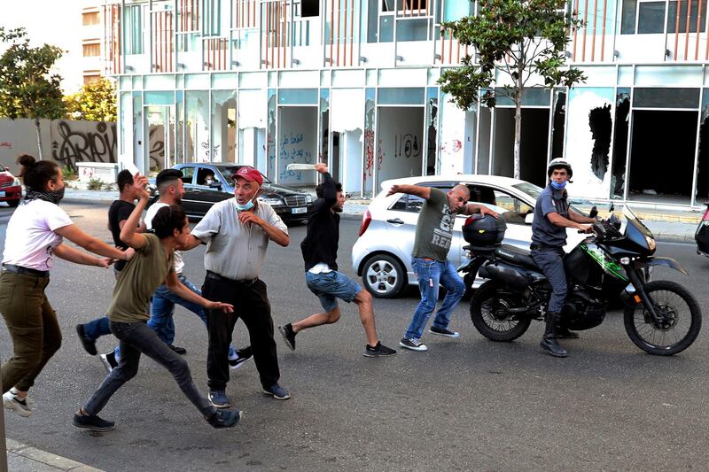 Protesters attack a plainclothes police officer, second right, after they saw him taking pictures of demonstrators in Beirut, Lebanon, on June 6, 2021.  AP