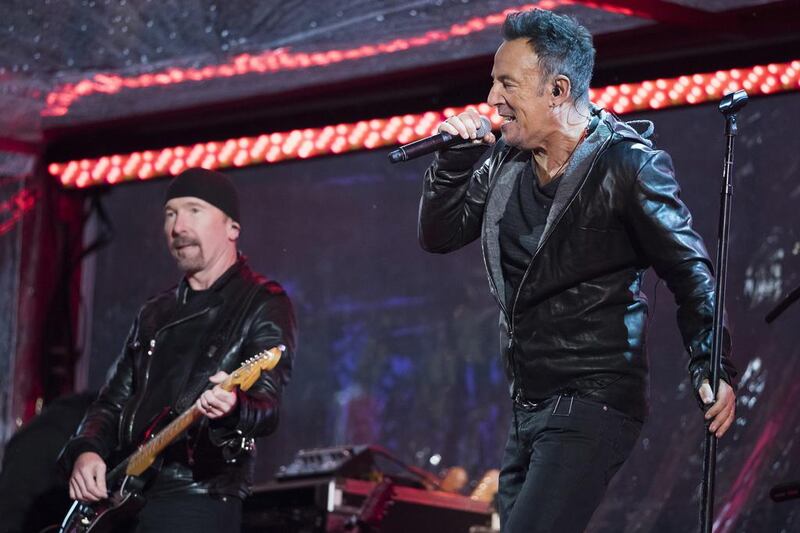 The Edge and Bruce Springsteen perform during the World AIDS Day (RED) concert in Times Square on Monday, December. 1, 2014. AP 