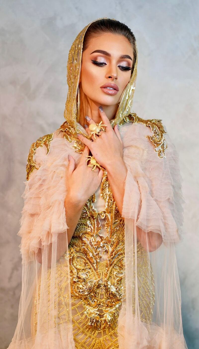 The photoshoot is themed The Power of Modesty, with gold-heavy look encompassing a ruffled cape and head cover, featuring heavy gold beadwork