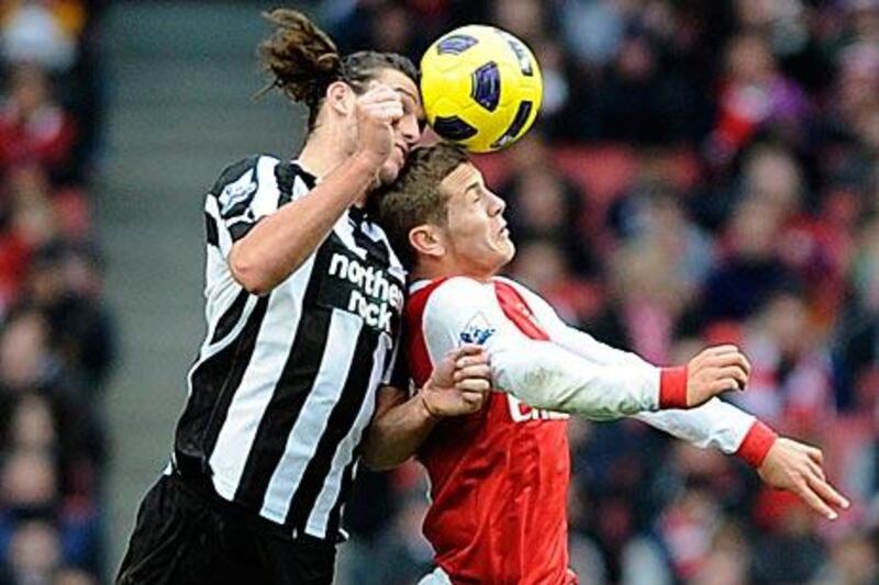 Newcastle's Andy Carroll outjumps Arsenal's Jack Wilshere during the Magpies' win at the Emirates Stadium.