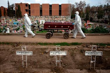 (FILES) In this file photo taken on August 5, 2020 Gravedigger Fernando Quezada (R), 27, and a co-worker carry a coffin at the General Cemetery in Santiago, amid the COVID-19 novel coronavirus pandemic. More than one million people have died from the coronavirus, according to an AFP toll, with no let-up in a pandemic that has ravaged the world economy, inflamed diplomatic tensions and upended lives from Indian slums and Brazilian jungles to America's biggest city. / AFP / Claudio REYES