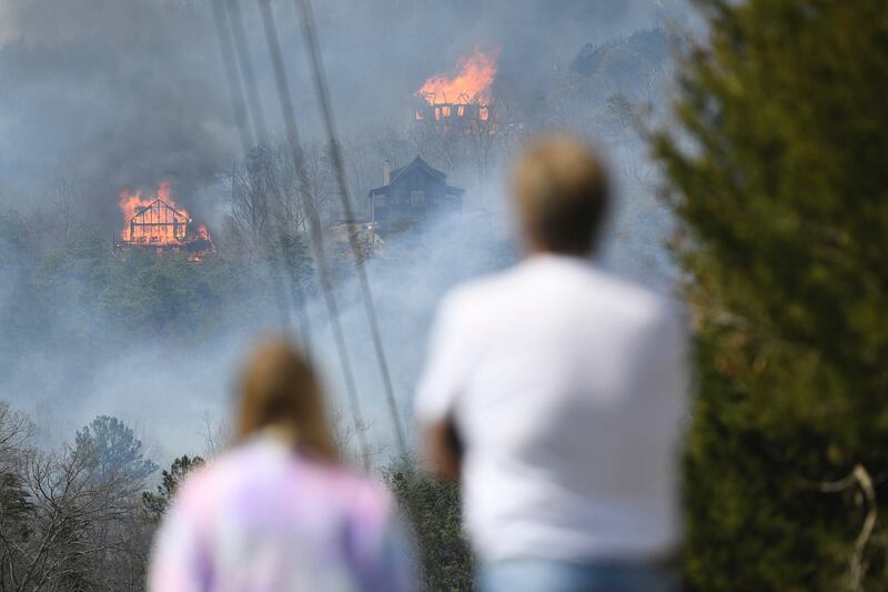Firefighters sought to get a handle on a wildfire spreading near Great Smoky Mountains National Park in Tennessee, amid mandatory evacuations as winds whipped up before a line of strong storms forecast to move in overnight.  Knoxville News Sentinel / AP