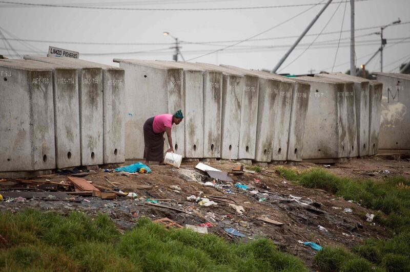 This photo taken on November 12, 2017 shows a woman throwing out waste water next to a line of toilets in an informal settlement in Langa, a mostly impoverished township, about 10km from the centre of Cape Town, on November 12, 2017.
AFP is presenting a worlwide photo theme on public toilets ahead of the United Nations World Toilet Day on November 19, 2017 as some 4.5 billion people live without a household toilet that safely disposes of their waste according to the UN. The Sustainable Development Goals, launched in 2015 by the UN, include a target to ensure everyone has access to a safely-managed household toilet by 2030. In 2013, the United Nations General Assembly officially designated November 19 as World Toilet Day. World Toilet Day is coordinated by UN-Water in collaboration with governments and partners. / AFP PHOTO / RODGER BOSCH