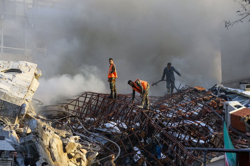 Emergency personnel extinguish a fire at the Iranian embassy compound in Damascus after it was hit by an Israeli air strike. AFP