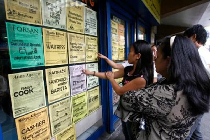 Applicants look at job offers displayed on a glass window of a recruitment agency in Manila in this October 9, 2010 file photo. An average of more than 3,000 workers leave the country daily to work as professionals, nurses, doctors, domestic helpers, seafarers and labourers overseas. The Philippines, the world's fourth biggest recipient of remittances after India, Mexico and China, received more than $1.5 billion worth of remittances monthly from Filipinos working and living overseas. REUTERS/Cheryl Ravelo/Files (PHILIPPINES - Tags: EMPLOYMENT BUSINESS SOCIETY)