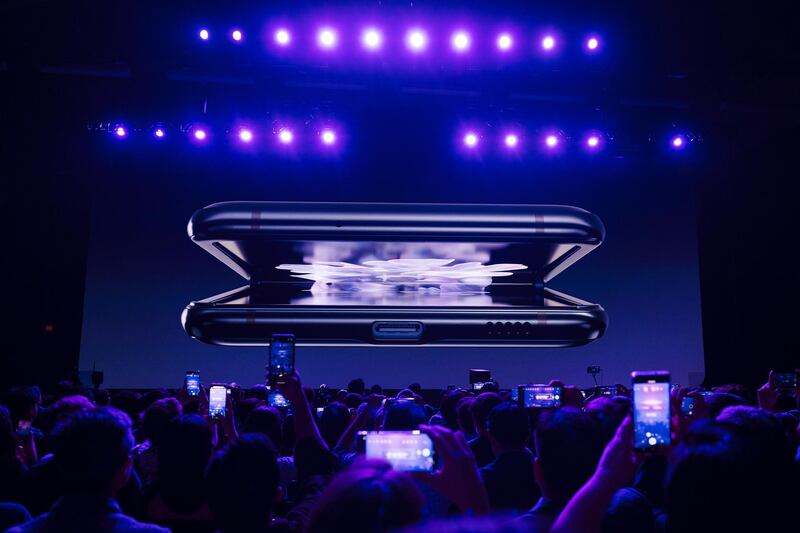 The Samsung Galaxy Z Flip smartphone is displayed on screen. Bloomberg