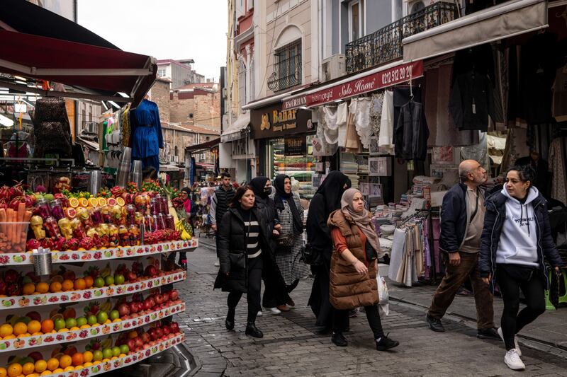 Pedestrians walk past a fresh fruit juice stand in Istanbul