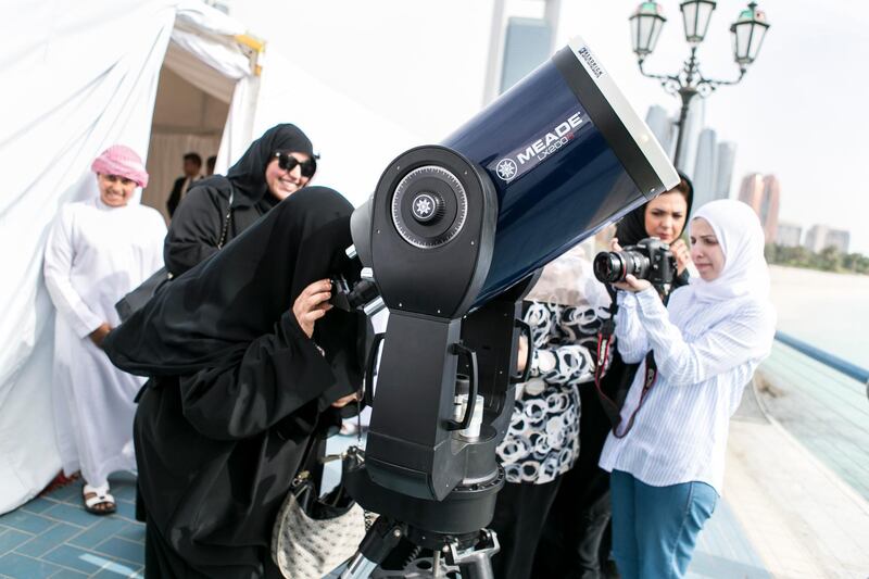 ABU DHABI, UNITED ARAB EMIRATES, MAY 9, 2016. A woman looks at Mercury's transit through a telescope at Abu Dhabi's corniche. 

UAE Space Agency is hosting a public event today, with specialised telescopes set up to monitor the phenomenon, which will be displayed on screens for viewing inside a tent.. Photo: Reem Mohammed/ The National (Reporter: Emmanuel Samoglou / Section: NA) Job ID 39118 *** Local Caption ***  RM_20160509_MERCURY_14.JPG