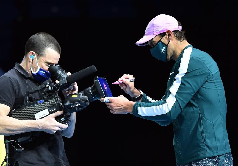 Rafael Nadal signs his autograph on a camera lens after beating Andrey Rublev. AFP