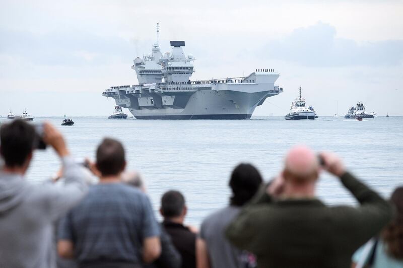 PORTSMOUTH, ENGLAND - AUGUST 16:  Members of the public gather to witness the arrival of the HMS Queen Elizabeth supercarrier as it heads into port on August 16, 2017 in Portsmouth, England.  The HMS Queen Elizabeth is the lead ship in the new Queen Elizabeth class of supercarriers. Weighing in at 65,000 tonnes she is the largest war ship deployed by the British Royal Navy.  (Photo by Leon Neal/Getty Images)