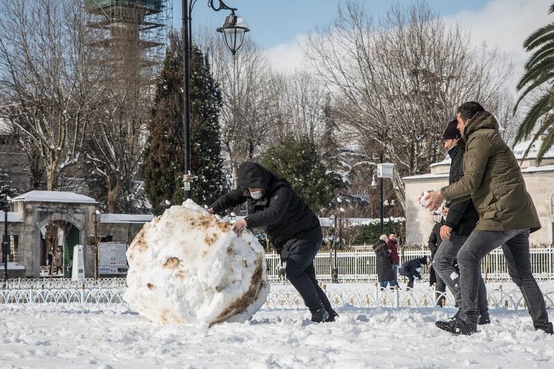A man pushes a large snowball in front of the Blue Mosque on February 17, 2021 in Istanbul, Turkey. An overnight cold snap brought heavy snowfall to Istanbul in the early morning, causing traffic disruptions. Getty Images