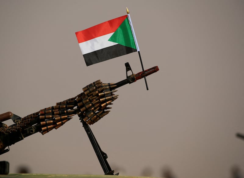 A Sudanese national flag is attached to a machine gun of Paramilitary Rapid Support Forces (RSF) soldiers. Reuters